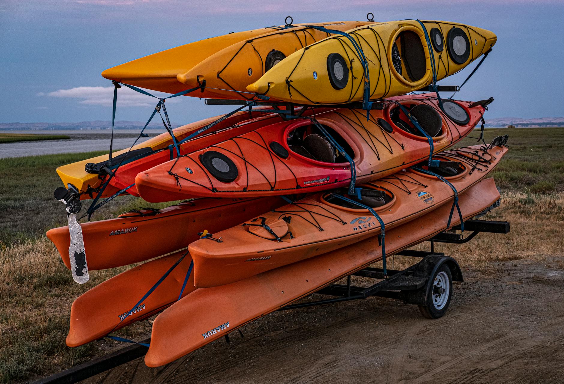 Kolorowe kajaki ułożone na przyczepie przed spływem
