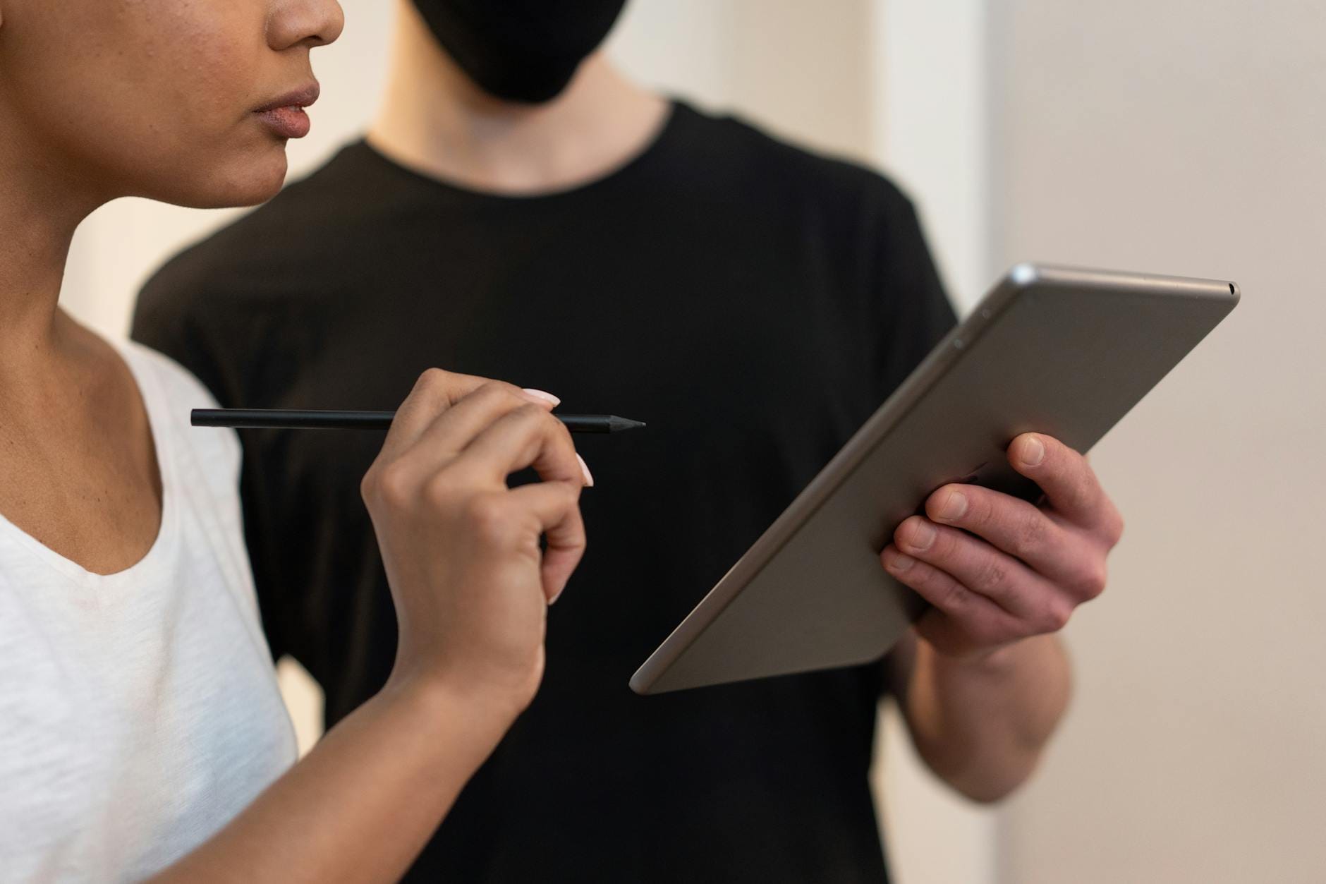 Dwie osoby analizują dane na tablecie z rysikiem w biurze