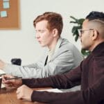 Dwoje pracowników biurowych omawia projekt przy laptopie w nowoczesnym biurze