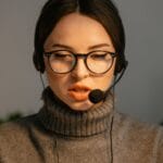 Agent call center w słuchawkach i okularach skupiony na rozmowie